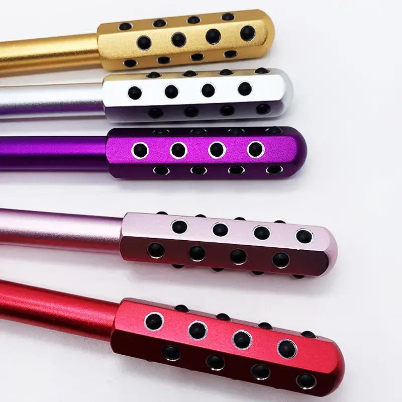 New Magna GermaBelle Roller Pro - Germanium Beauty Face Roller - Close-up overhead view of 5 color variants showing germanium ball inlay detail: gold, silver, purple, pink, and red