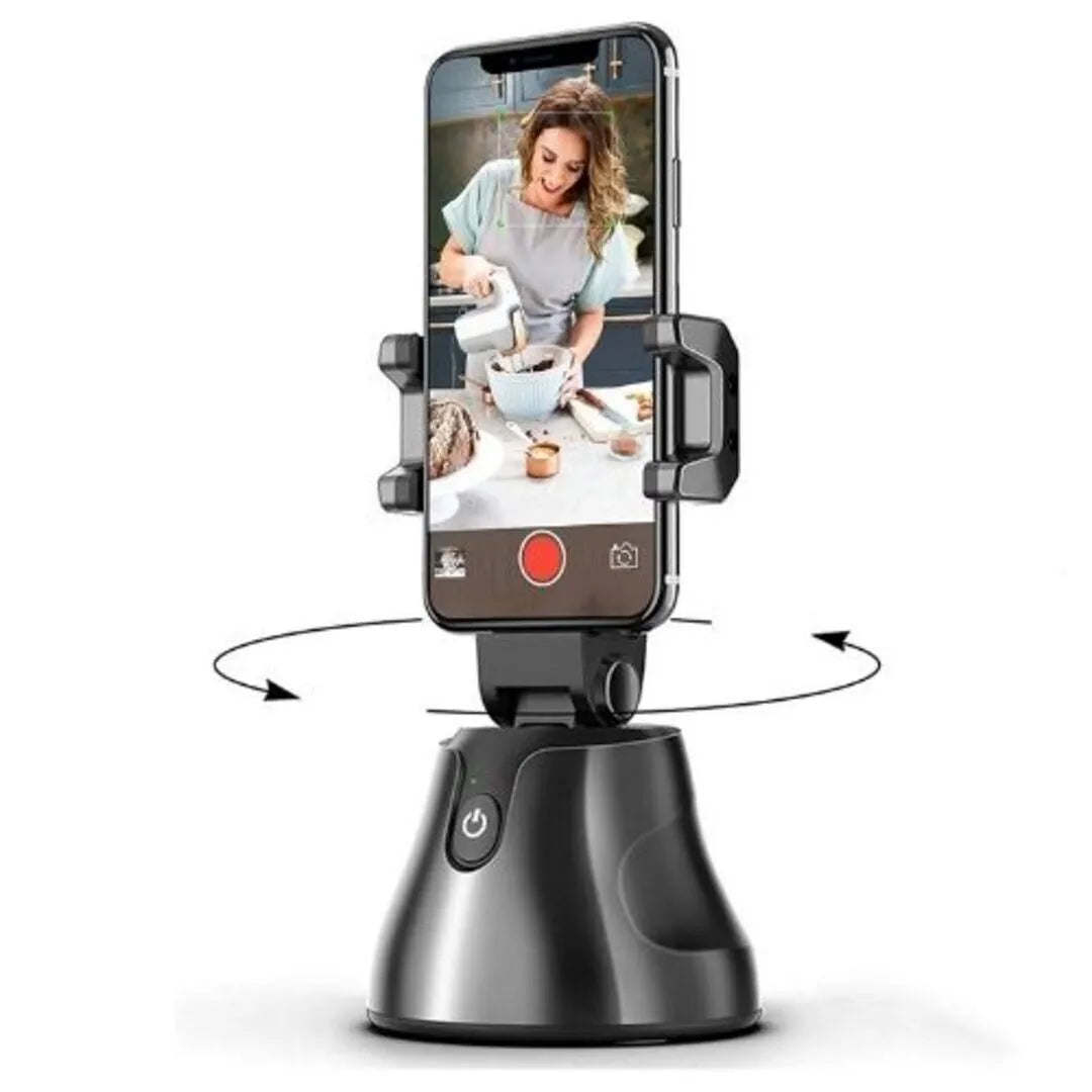 New Magna TrackFrame Pro AI face tracking phone holder with black adjustable clamp holding smartphone, motorized 360° rotating base with power button - woman on screen being tracked while baking - hands-free content creation for TikTok and YouTube